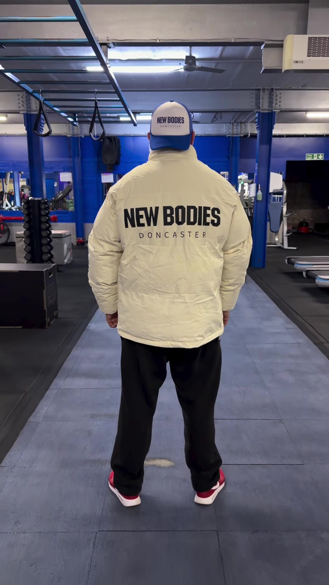 The gym floor at New Bodies with royal-blue pillars and rows of equipment